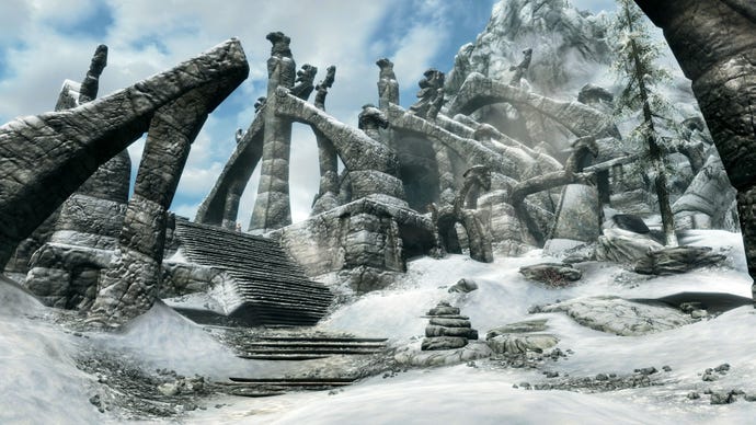 Stone steps leading upward to a ruined barrow made of collapsed arches on a mountainside in Skyrim.